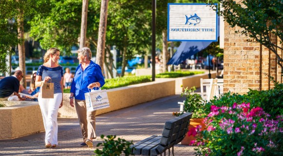 two women walking the Shelter Cove Harbour and Marina shops outside of the Southern Tide store