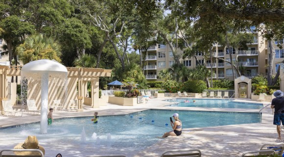 large community pool with spray area and lots of seating